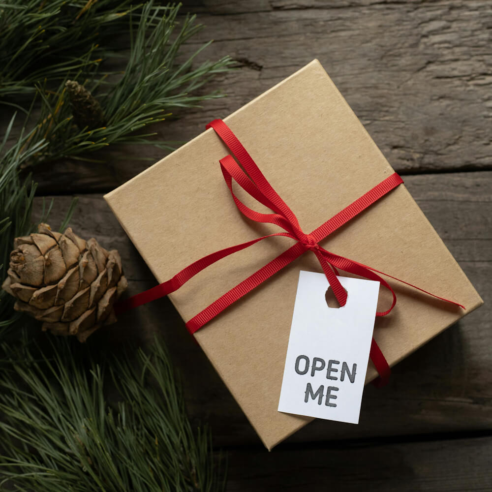 Cardboard box with "Open Me" label and red ribbon