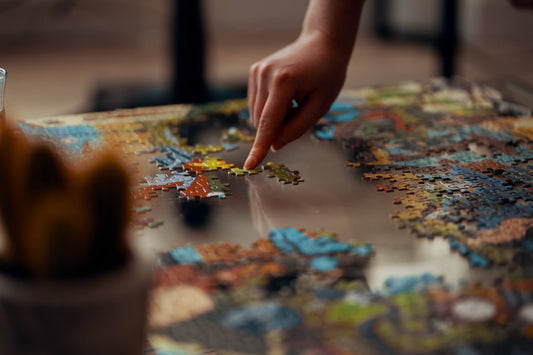 Person using their finger to place a piece in a jigsaw puzzle